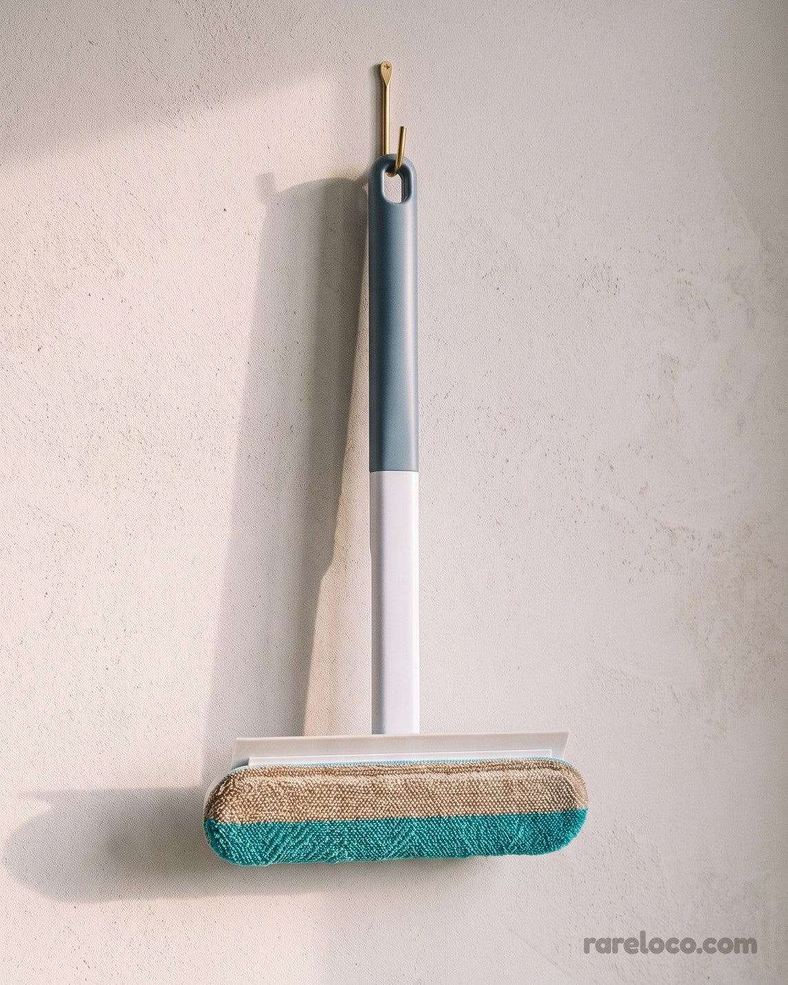 The brush hanging on a wall hook with its extension handle