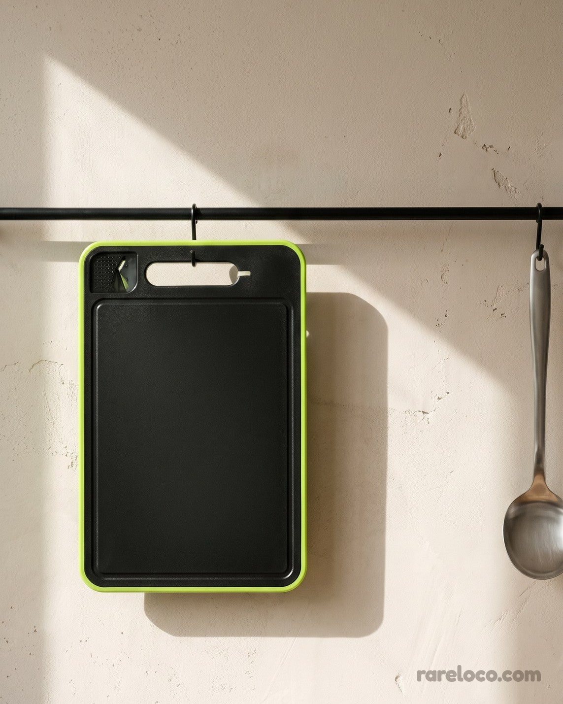 Cutting board hanging from a kitchen rail by its handle