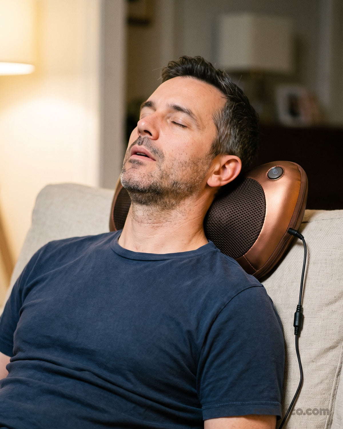 A man leaning back on the sofa with the pillow behind his neck